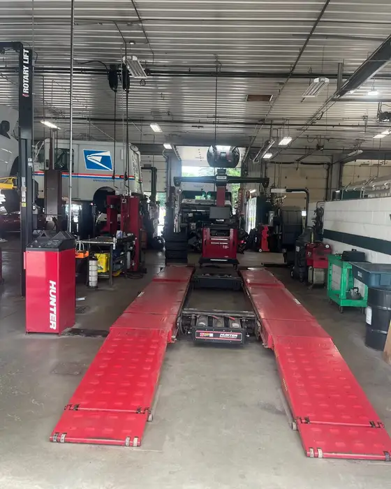 A United States Postal Service vehicle in for fleet service beside the alignment rack at Fogg's Automotive